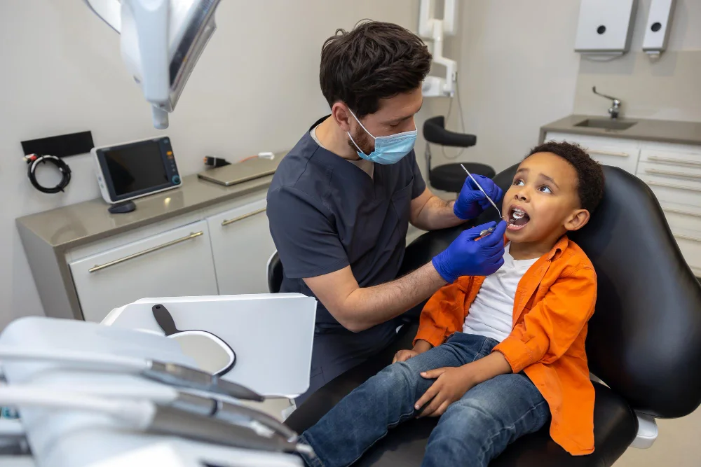 Pediatric dentist helping a child cooperate during dental treatment in Faridabad