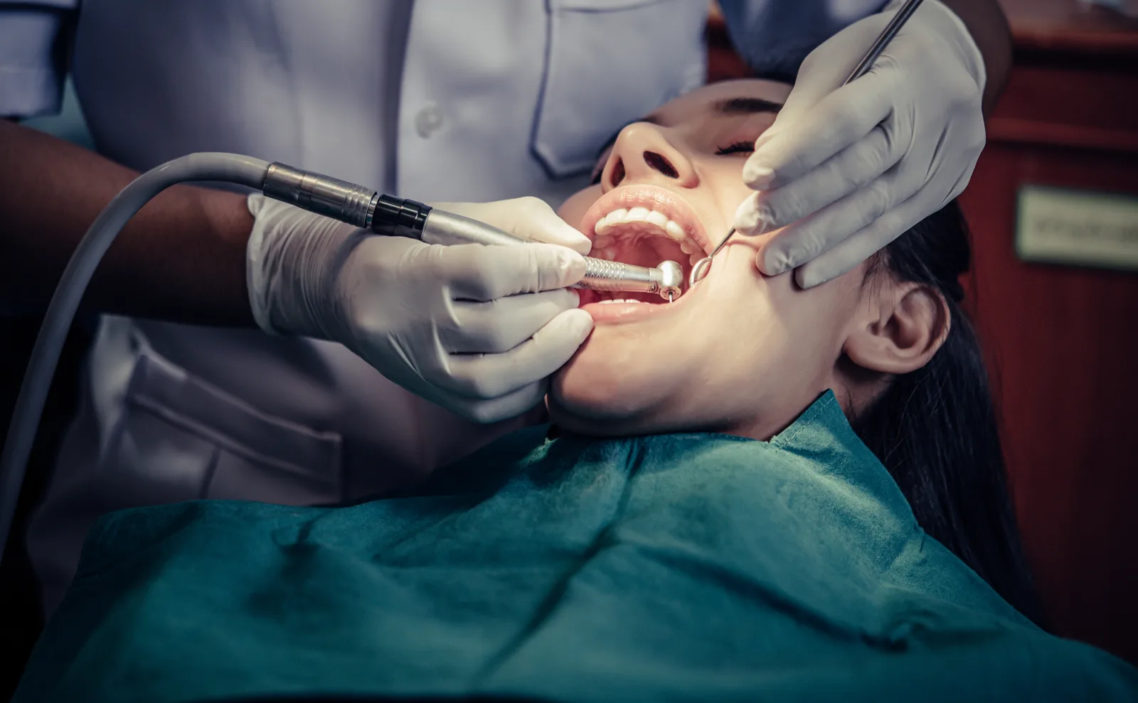 Dentist treating a patient during a dental procedure for root canal symptoms